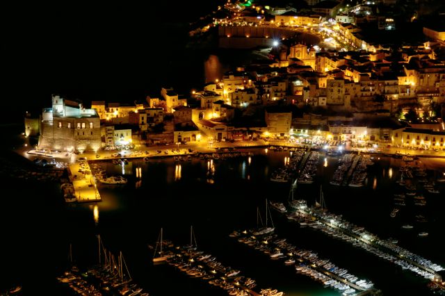 A mesmerizing night view of Castellammare del Golfo harbor illuminated in Sicily, Italy.